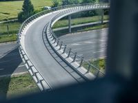 a view from a window of traffic on a highway with a bike path below them