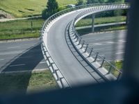 a view from a window of traffic on a highway with a bike path below them