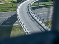 a view from a window of traffic on a highway with a bike path below them