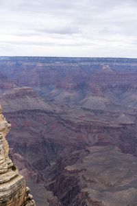 a hiker standing on the edge of a cliff in the grand canyon of south rim