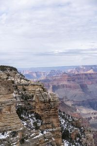 a hiker standing on the edge of a cliff in the grand canyon of south rim