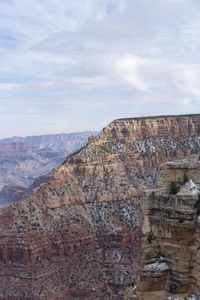 a hiker standing on the edge of a cliff in the grand canyon of south rim