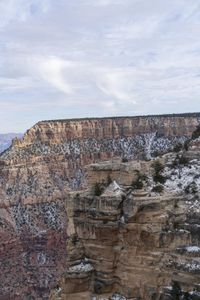 a hiker standing on the edge of a cliff in the grand canyon of south rim