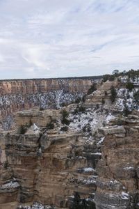 a hiker standing on the edge of a cliff in the grand canyon of south rim