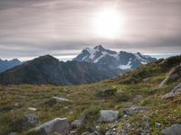 a group of hikers trekking down the trail of high alpine mountains at sunset