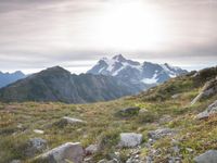 a group of hikers trekking down the trail of high alpine mountains at sunset