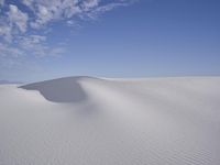 two people are hiking through the white sands in the desert for water sports or snowboarding
