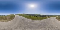 a wide angle view of a hilly mountain road with a bicycle going up the slope