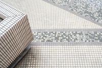 a bathroom with mosaic tiles is shown here in this image, there's only the toilet