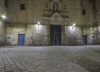 a clock sitting above the front entrance of a building at night in france to see a full set of lights