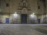 a clock sitting above the front entrance of a building at night in france to see a full set of lights