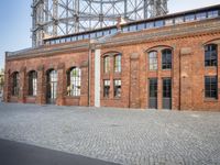 there is an old red brick building in the middle of the square with trees growing inside