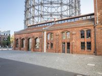 there is an old red brick building in the middle of the square with trees growing inside