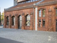 there is an old red brick building in the middle of the square with trees growing inside