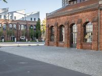 there is an old red brick building in the middle of the square with trees growing inside