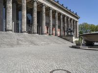 there is a large fountain next to some columns in the building on one side and another on the other