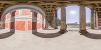 two 360 glasses are seen showing a red building with columns and windows at the base