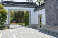 the entrance to a garden with many trees and shrubs in it's center circle