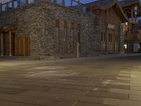 the night time view of an outdoor area with a brick building and lights glowing on