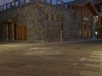 the night time view of an outdoor area with a brick building and lights glowing on