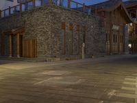 the night time view of an outdoor area with a brick building and lights glowing on