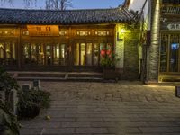 an entrance to a house on a chinese street at twilight with plants outside of the door