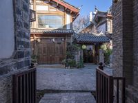 a courtyard with an alley way and old buildings, seen from one side of the road