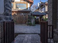 a courtyard with an alley way and old buildings, seen from one side of the road