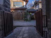 a courtyard with an alley way and old buildings, seen from one side of the road