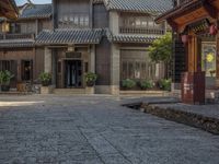 a large chinese style building with wooden doors and windows and green plants growing from brick walls and pillars