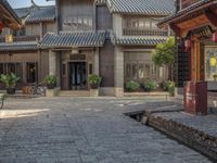 a large chinese style building with wooden doors and windows and green plants growing from brick walls and pillars