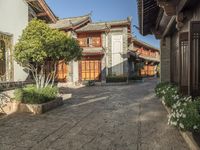 a cobblestone street leading to an old - fashioned house that looks like an oriental style village