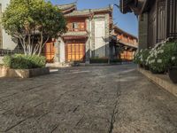 a cobblestone street leading to an old - fashioned house that looks like an oriental style village