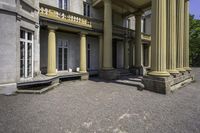 an old style mansion has pillars and a staircase up to the front door and window