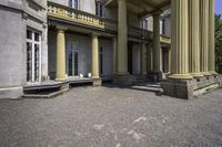 an old style mansion has pillars and a staircase up to the front door and window