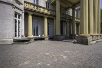 an old style mansion has pillars and a staircase up to the front door and window