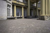 an old style mansion has pillars and a staircase up to the front door and window