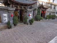 a building is decorated with oriental paintings and stone tile floors and walls and columns with red lights and lanterns