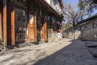 an alley in china lined with shops along the wall's edge, on a sunny, clear day