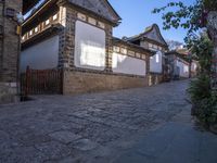 street view of old building with lanterns on top of bricked area, in chinese village