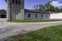 the view of a small church through a driveway by a lawn with a fire hydrant