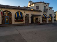 a picture of a building with awnings and windows on each side of the street