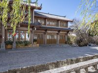 an asian building is pictured surrounded by a stone road in china - like country land