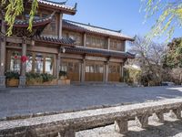 an asian building is pictured surrounded by a stone road in china - like country land