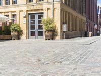 a very old city square that has several potted plants on it's corner