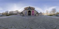 a panoramic view of a historic building in a city center with a circular perspective of the plaza