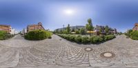 a 360 - view lens image shows a beautiful town with beautiful cobblestones and trees