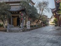 a long street with many buildings and trees on it's sides with red lanterns