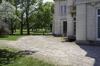 a bike parked in front of an old mansion building on the grass in front of it is an empty path