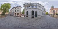 a curved shot of a building with three front doors that are open and shown in a fish eye view